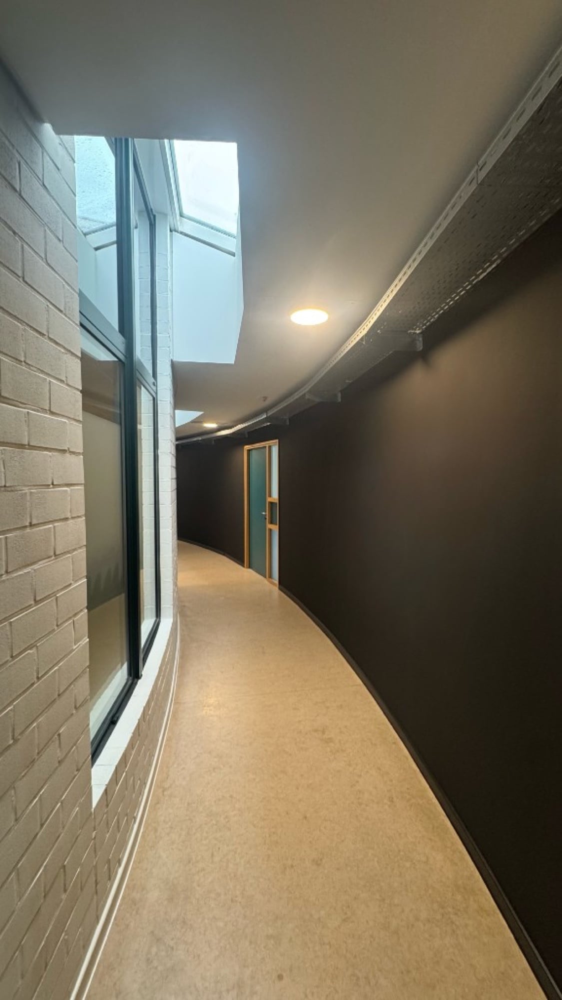 Overzicht gebogen gang PXL Hogeschool Hasselt — donkere accentwanden geschilderd door Fresh Decor Limburg