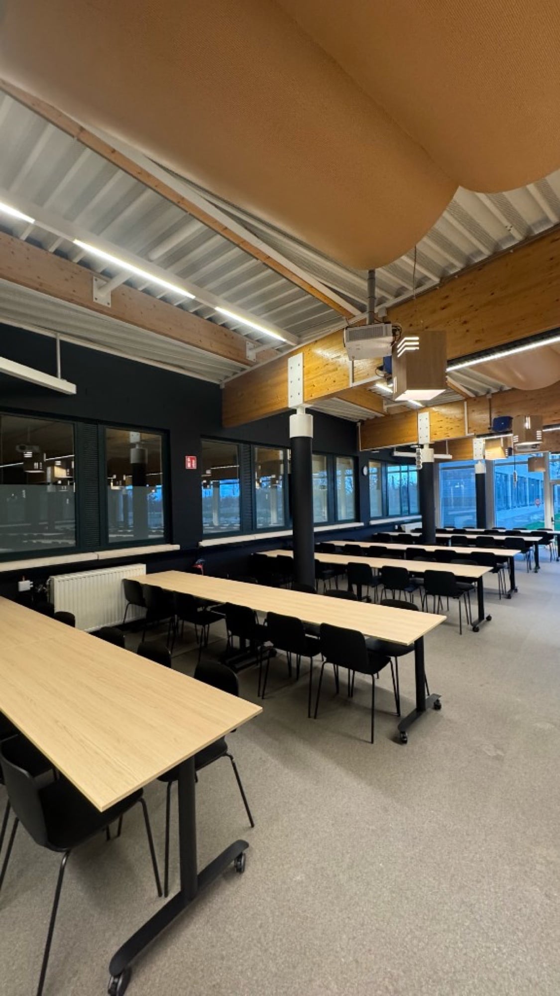 Klaslokaal PXL Hogeschool met donkere accentwanden en houten plafond — zakelijke schilderwerken Fresh Decor Hasselt