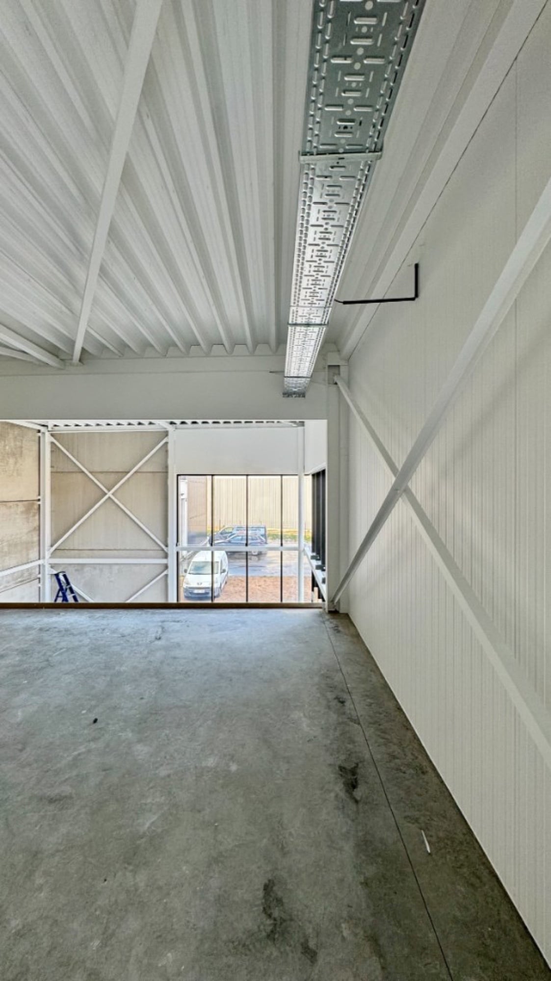 Industriële loods met strak wit gespoten wanden door Fresh Decor — airless spuitwerken bedrijfshal België