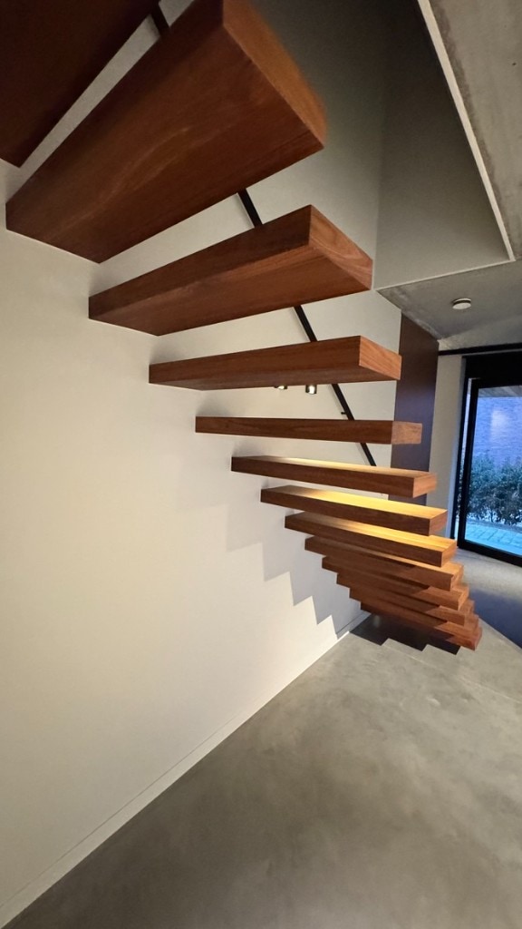 Zwevende trap & witte muren Moderne zwevende houten trap tegen een strak mat wit geschilderde muur — binnenschilderwerk Fresh Decor Limburg