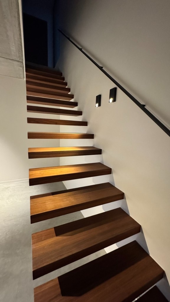 Minimalistische trapgevel Strak geschilderde witte muren met moderne houten zwevende trap — professioneel binnenschilderwerk Fresh Decor