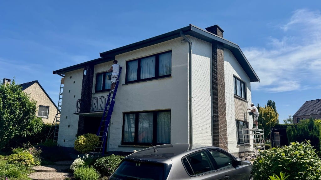Schilders van Fresh Decor schilderen de witte bakstenen gevel van een vrijstaande woning met bruine schoorsteen in Oudsbergen — buitenschilderwerk en gevelschilderen in Limburg