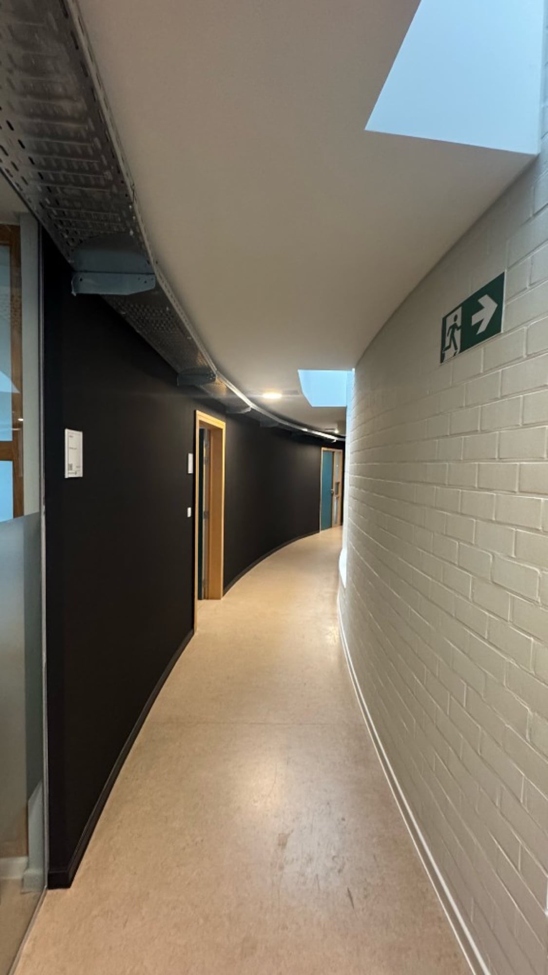 Gebogen gang PXL Hogeschool met zwart geschilderde wanden en witte bakstenen — schilderwerken Fresh Decor Hasselt