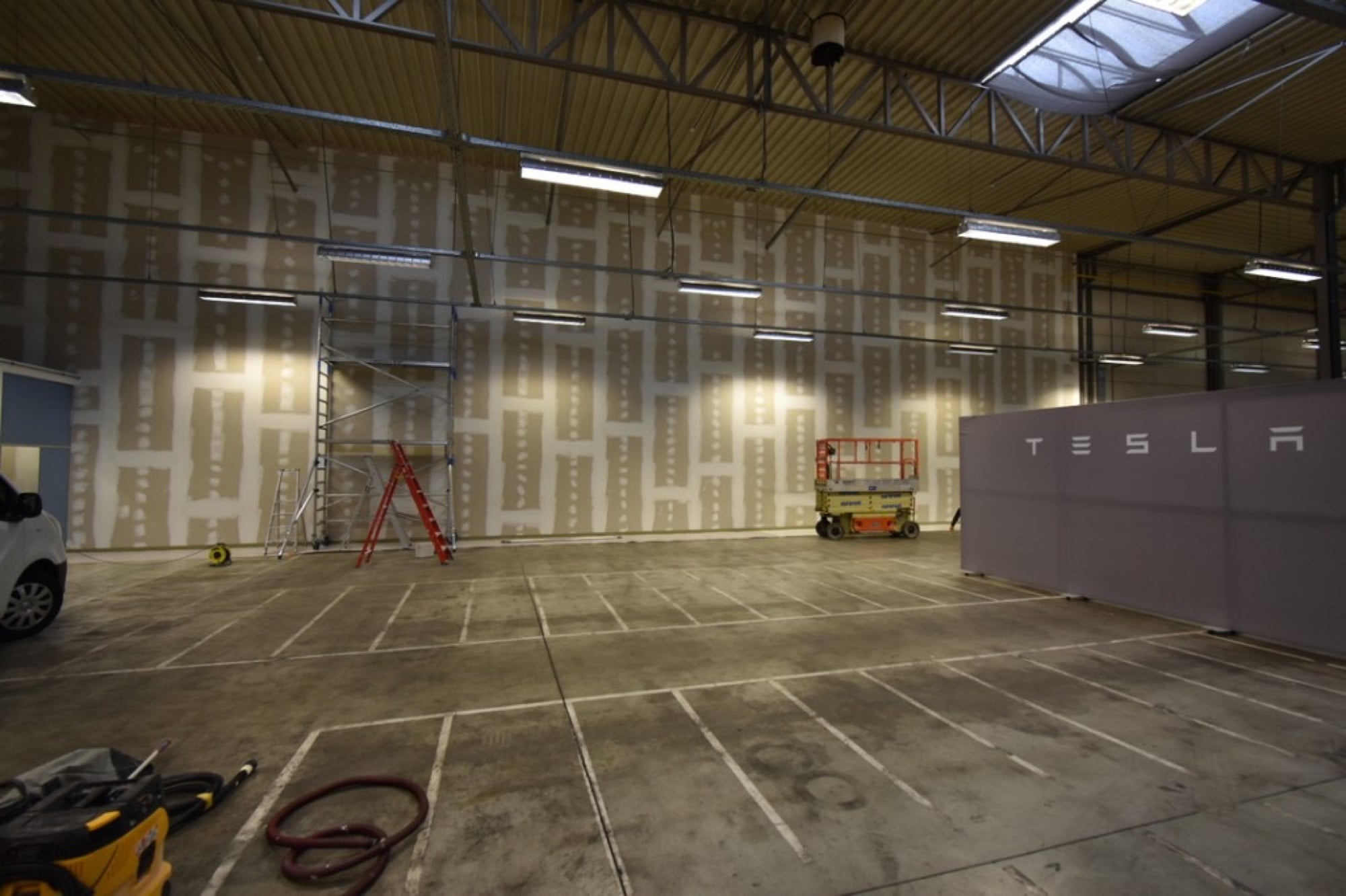 Tesla Service Center in Limburg — schilderwerken in uitvoering, voorbereidende grondlaag op showroomwanden door Fresh Decor